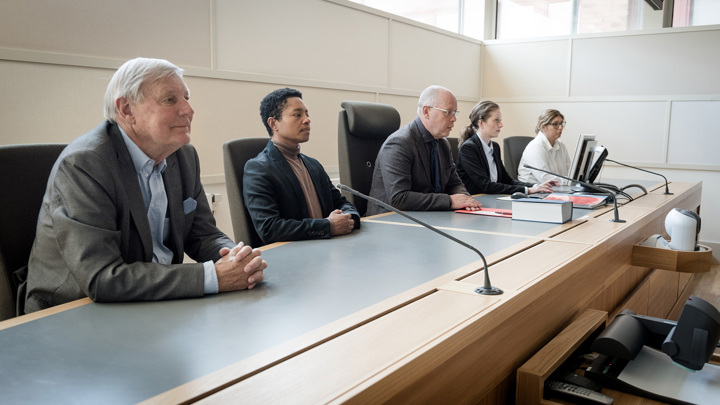 Bild på en domarbänk där fem personer sitter