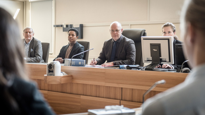 Bild på en domarbänk där det sitter fyra personer