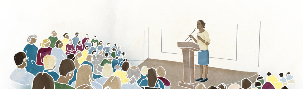 En kvinna föreläser i en aula.