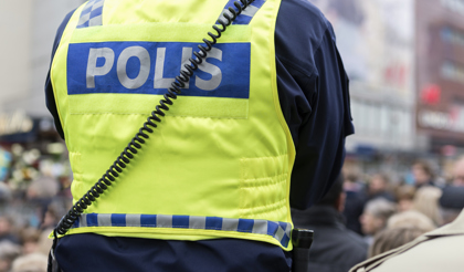 En polis står framför en folksamling.