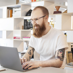 Man sitter framför en dator på ett kontor.