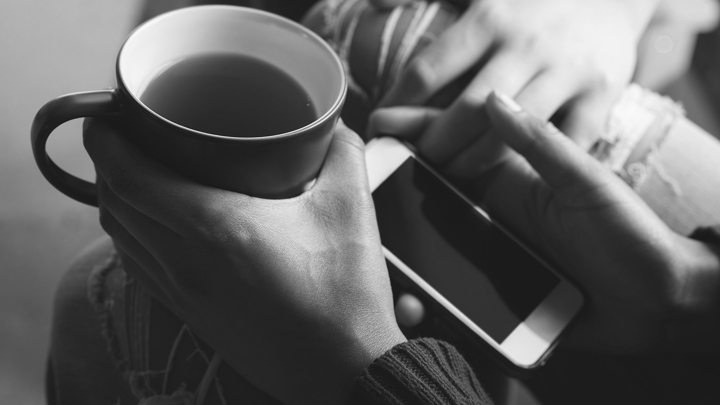 En kaffekopp och mobiltelefon.