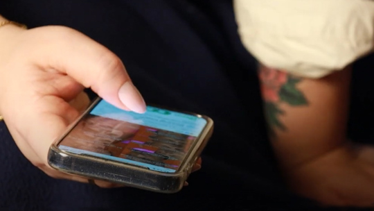 Bild på ung person som håller i en mobiltelefon