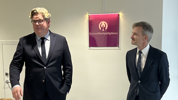 Anders Alenskär och Gunnar Strömmer avtäcker en skylt med Brottsoffermyndighetens logotyp.