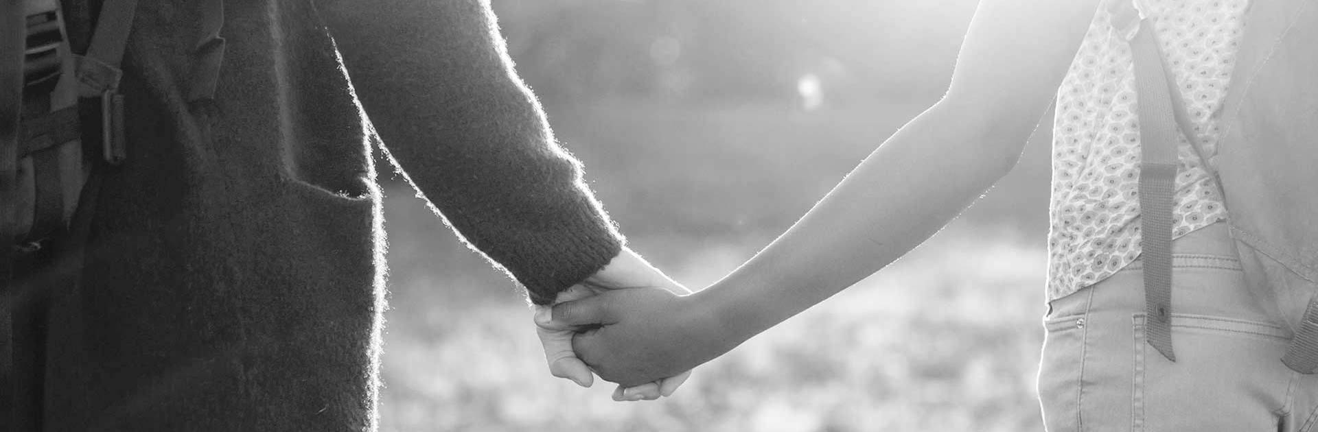 Två unga personer håller varandra i handen.